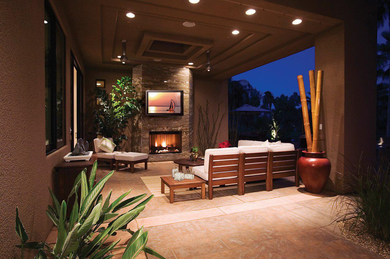 Cozy outdoor patio with elaborate tray ceiling including outdoor TV and fireplace
