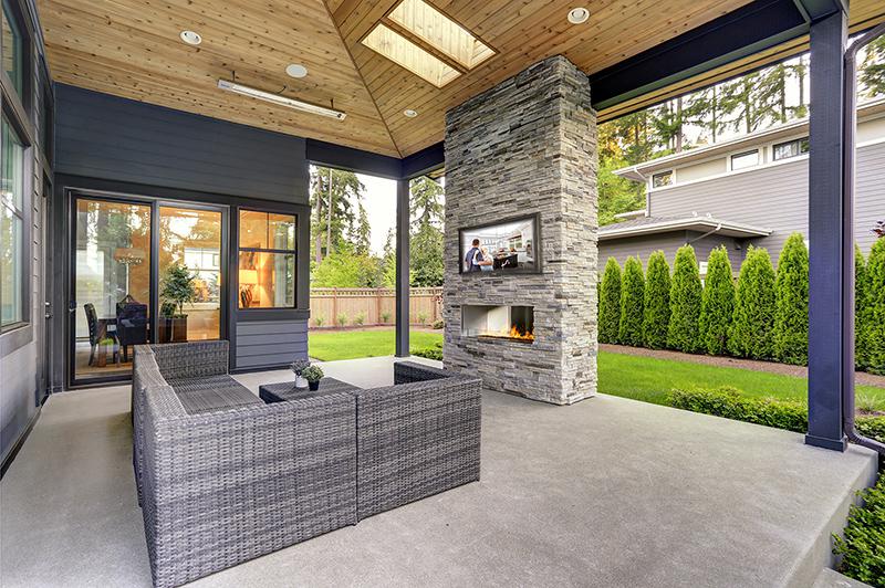 A smaller patio with a fireplace and outdoor TV cabinet mounted directly above fireplace