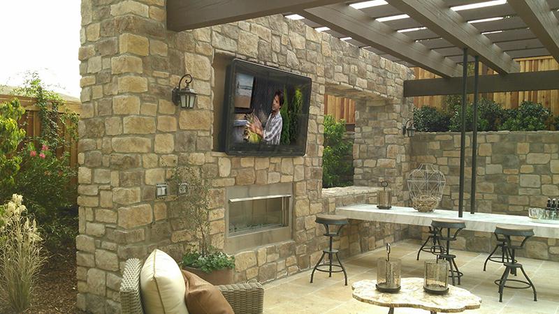 A weatherproof TV cabinet, outside under a pergola and inside a stone entertainment zone