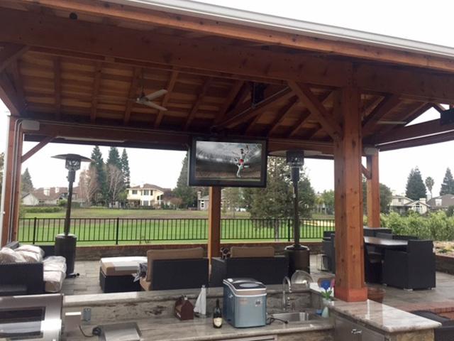 Amazing outdoor TV, kitchen, living, and dining room combo in large pavilion