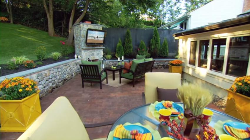 Low receded brick patio with living room and dining room combo seating featuring outdoor TV enclosure (patio was featured on Spontaneous Construction TV show) 